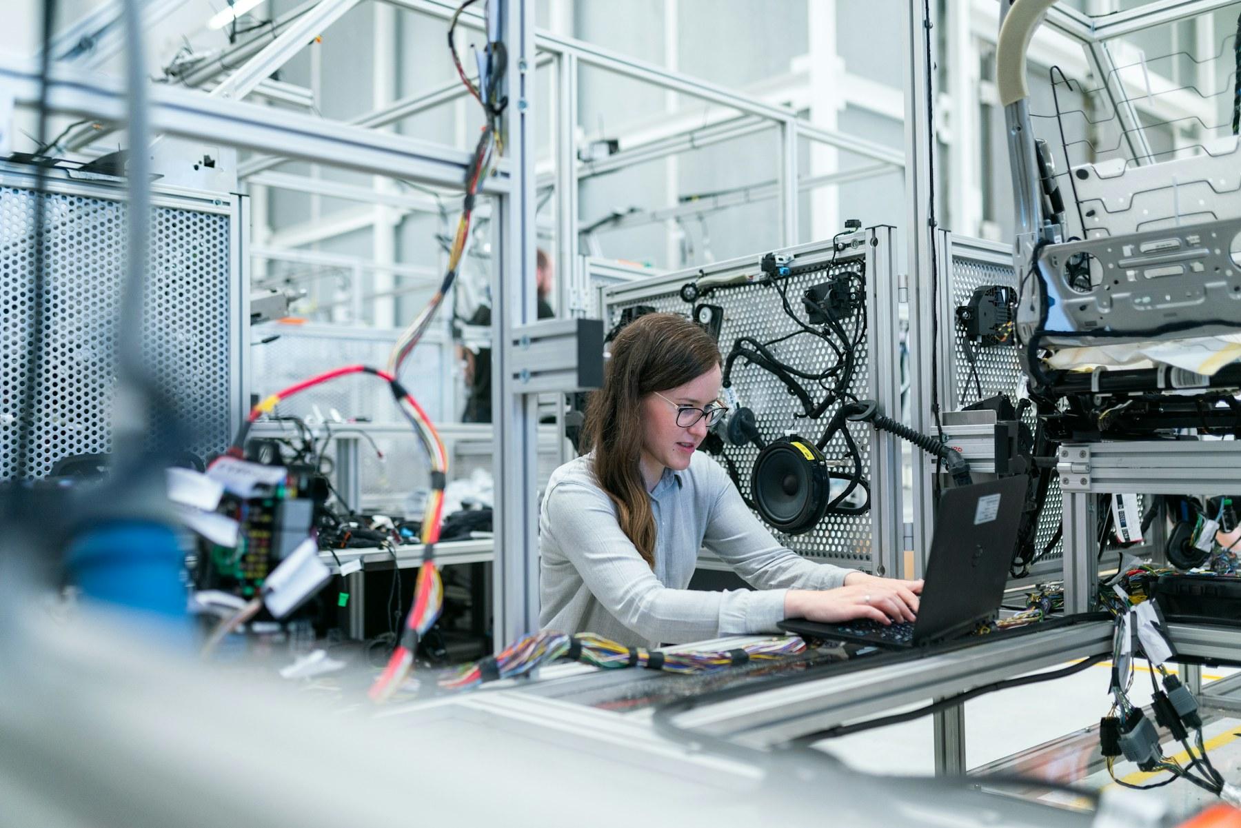 An engineer working with technology on a production floor